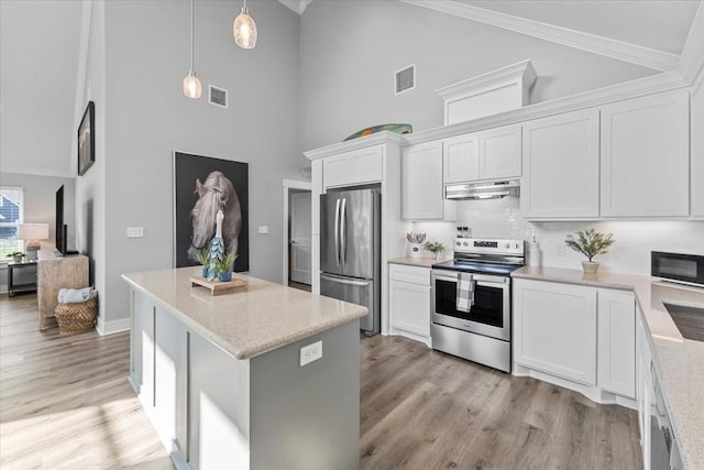 kitchen featuring high vaulted ceiling, under cabinet range hood, appliances with stainless steel finishes, and visible vents