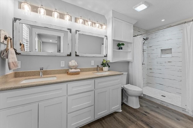 bathroom with toilet, a sink, and tiled shower