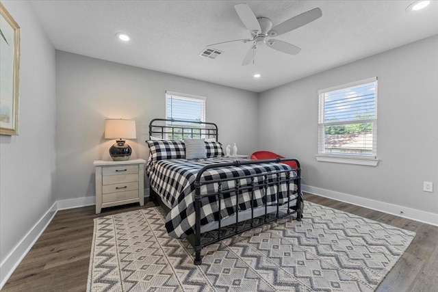 bedroom with baseboards, wood finished floors, and visible vents