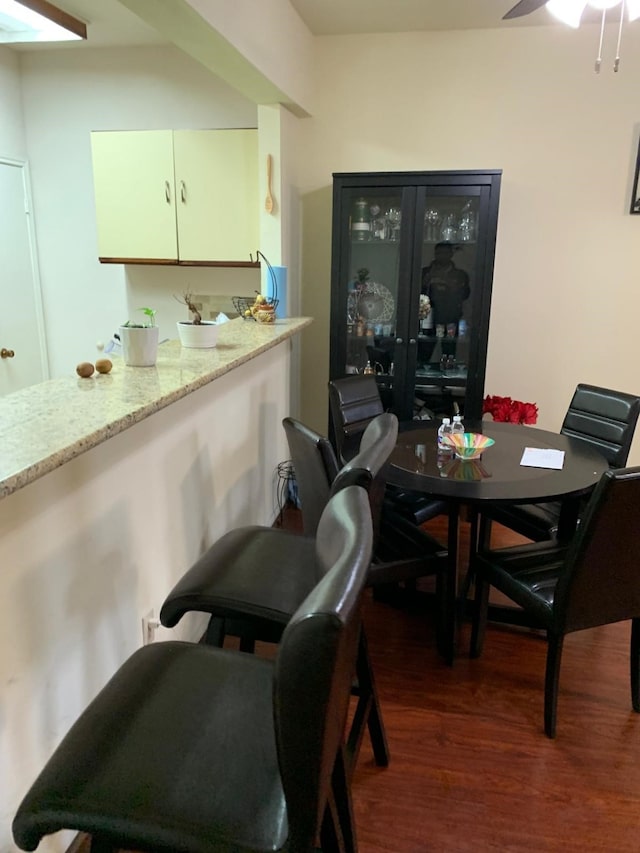 dining space featuring ceiling fan and dark wood-style flooring
