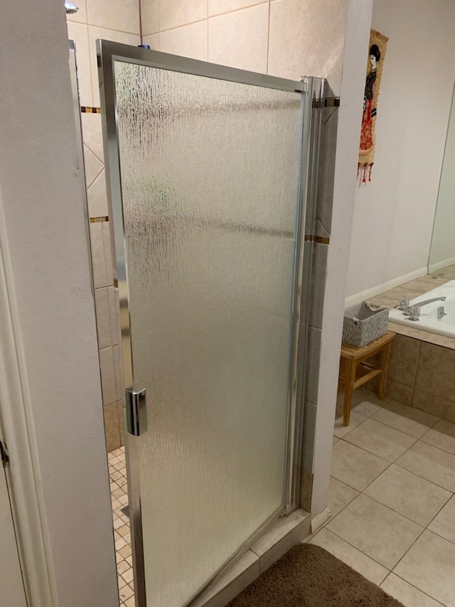 full bathroom with a shower stall, a garden tub, and tile patterned flooring