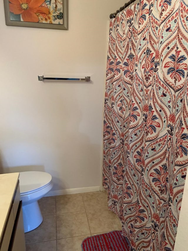 bathroom with tile patterned floors, toilet, vanity, a shower with curtain, and baseboards