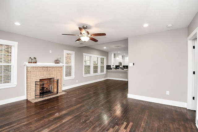 3013 Prospect St, Houston, TX 77004 - unfurnished living room with ceiling fan with notable chandelier, baseboards, a fireplace, and wood-type flooring