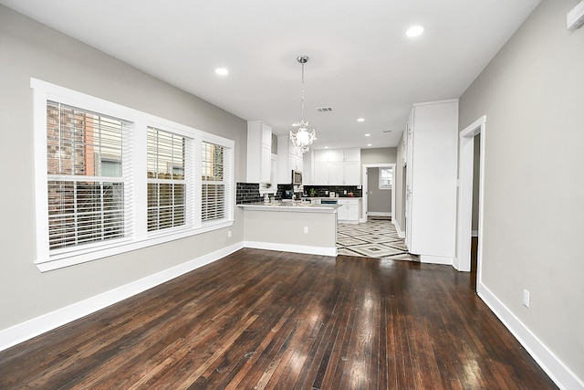 3013 Prospect St, Houston, TX 77004 - unfurnished living room with recessed lighting, hardwood / wood-style floors, an inviting chandelier, visible vents, and baseboards