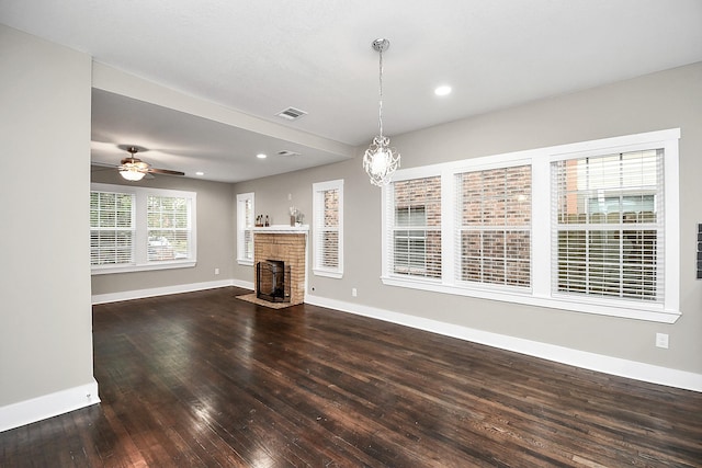 3013 Prospect St, Houston, TX 77004 - unfurnished living room featuring ceiling fan with notable chandelier, hardwood / wood-style flooring, baseboards, a brick fireplace, and visible vents