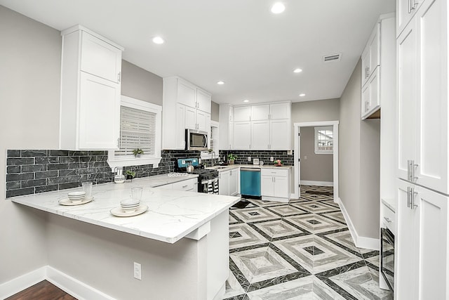 3013 Prospect St, Houston, TX 77004 - kitchen with range with gas stovetop, a peninsula, stainless steel microwave, baseboards, and dishwashing machine