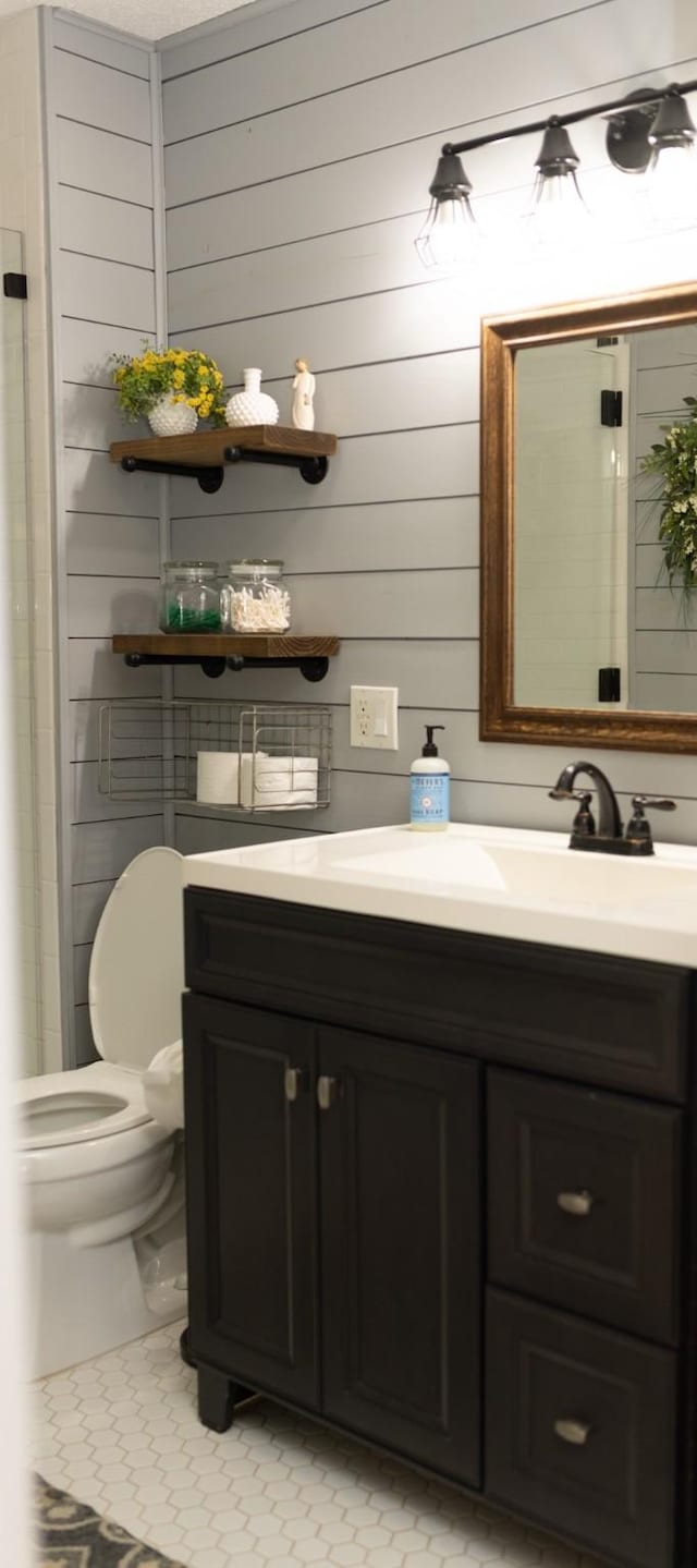 1867 Fm 2423, Grapeland, TX 75844 - bathroom featuring tile patterned flooring, toilet, vanity, and wood walls