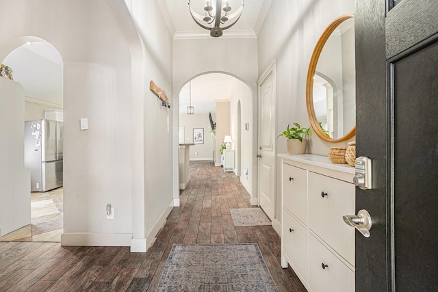 2884 Shallow Brook Ln, Dickinson, TX 77539 - foyer entrance featuring arched walkways, a chandelier, a towering ceiling, dark wood finished floors, and ornamental molding