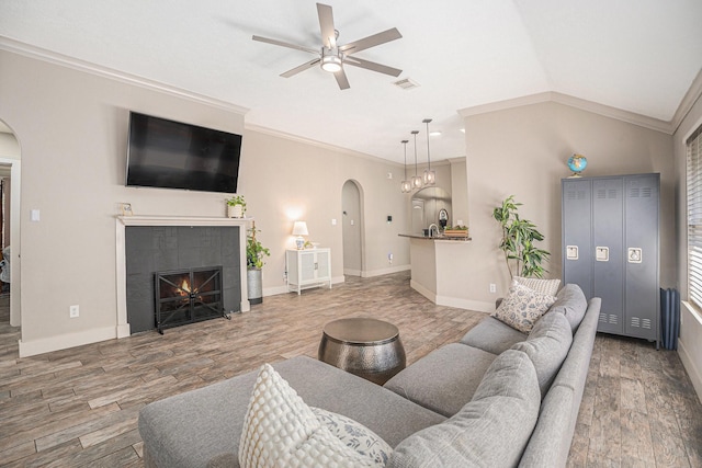 2884 Shallow Brook Ln, Dickinson, TX 77539 - living room with arched walkways, a ceiling fan, wood finished floors, lofted ceiling, and ornamental molding