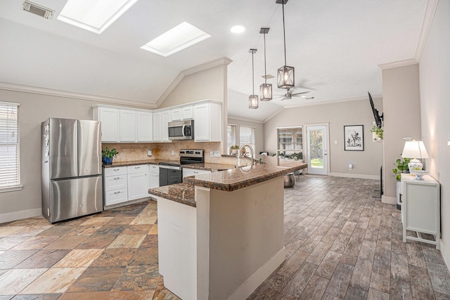 2884 Shallow Brook Ln, Dickinson, TX 77539 - kitchen featuring stainless steel appliances, a peninsula, vaulted ceiling, baseboards, and crown molding