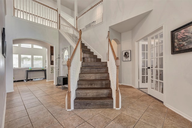 6919 S Gold River Cir, Missouri City, TX 77459 - entrance foyer featuring tile patterned floors, a towering ceiling, french doors, arched walkways, and stairs