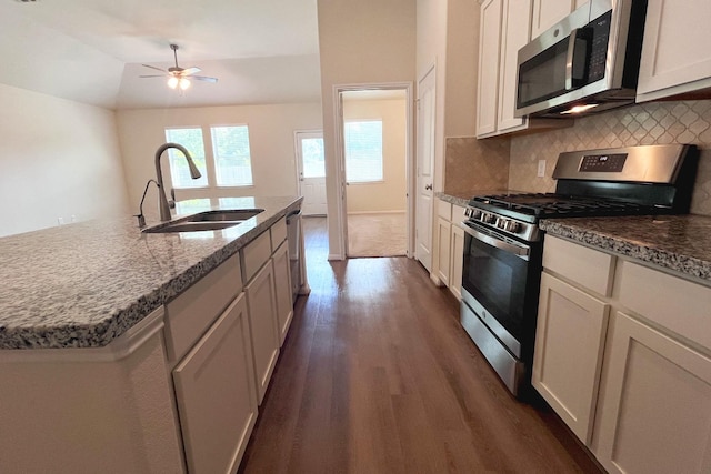18871 Cedar Birch Ln, Magnolia, TX 77355 - kitchen with appliances with stainless steel finishes, a sink, dark wood finished floors, backsplash, and vaulted ceiling