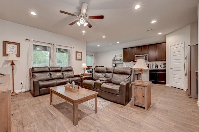 living room with ceiling fan, visible vents, light wood-style floors, baseboards, and recessed lighting