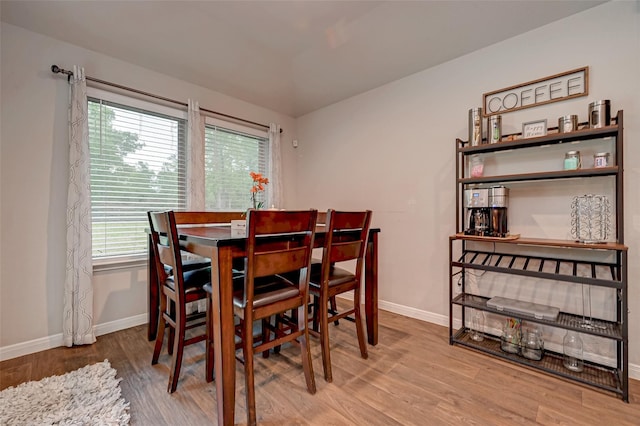 dining area featuring baseboards, wood finished floors, and a healthy amount of sunlight