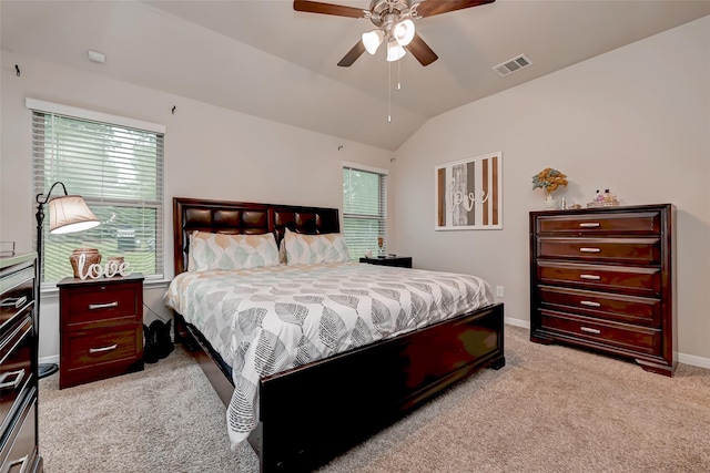 bedroom featuring lofted ceiling, visible vents, ceiling fan, baseboards, and light carpet