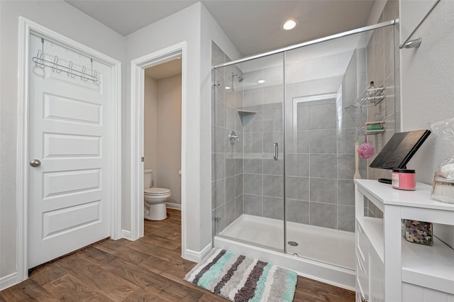 full bath with wood finished floors, toilet, recessed lighting, and a stall shower