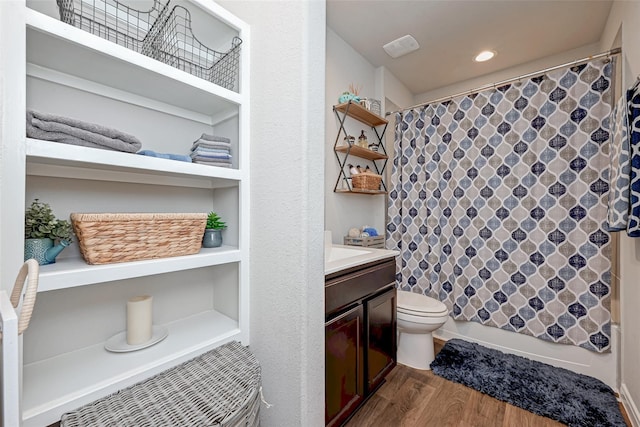 bathroom featuring wood finished floors, toilet, and vanity