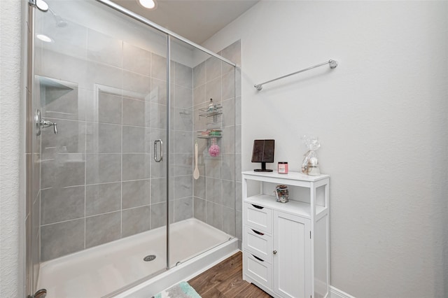 full bathroom with a stall shower and wood finished floors