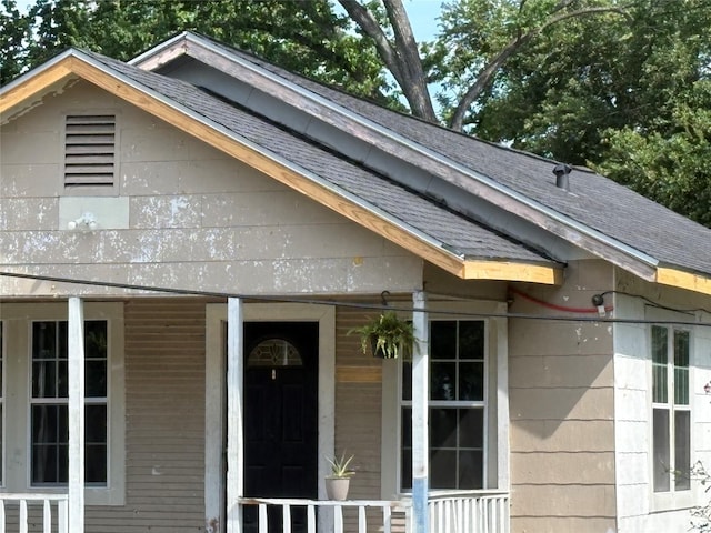 exterior space featuring a porch and a shingled roof