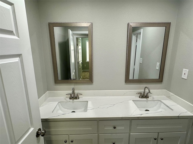 bathroom featuring a sink and double vanity