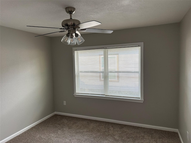 carpeted empty room featuring a textured ceiling, a ceiling fan, and baseboards
