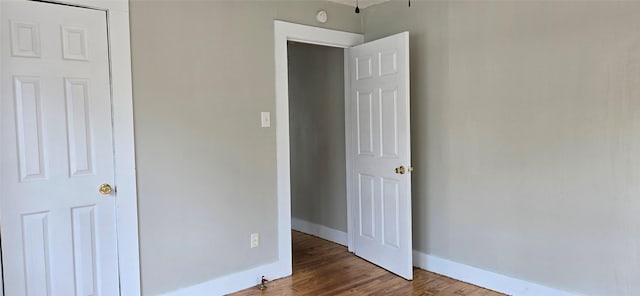 unfurnished bedroom with baseboards and wood finished floors