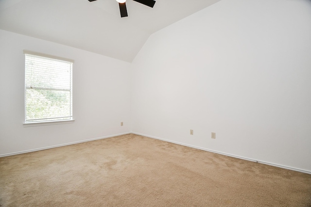 carpeted empty room featuring lofted ceiling, a ceiling fan, and baseboards
