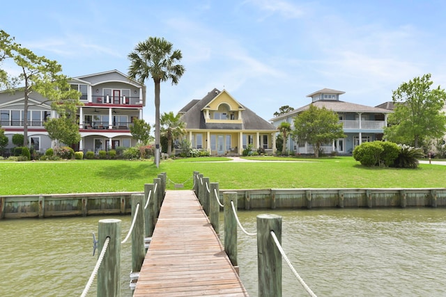 view of dock featuring a lawn and a water view