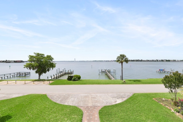 dock area featuring a lawn, boat lift, and a water view