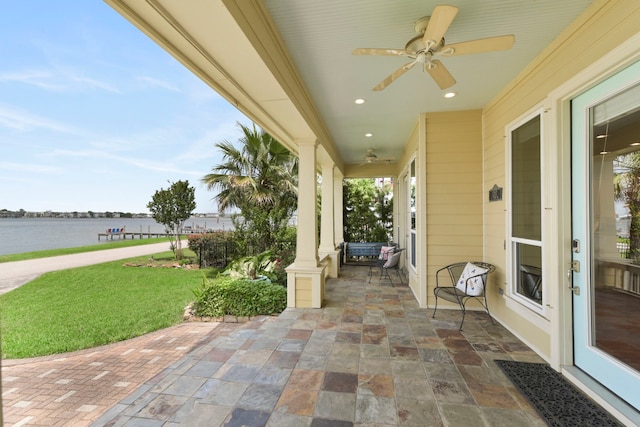 view of patio featuring a water view and a ceiling fan
