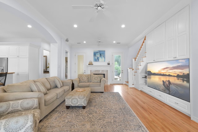 living room with recessed lighting, light wood-style flooring, stairs, and ceiling fan