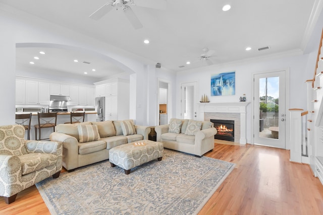 1207 N Shore Dr, Clear Lake Shores, TX 77565 - living room with ceiling fan, light wood-type flooring, arched walkways, a fireplace with flush hearth, and recessed lighting