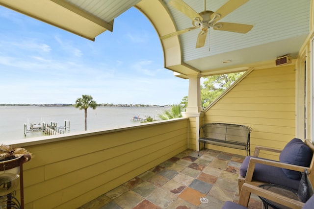 balcony featuring a ceiling fan and a water view