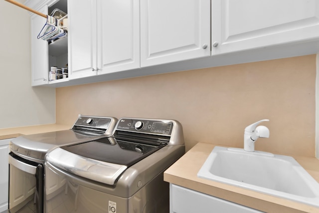 laundry room featuring cabinet space, a sink, and independent washer and dryer