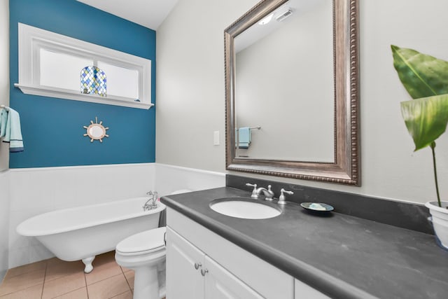 bathroom with tile patterned floors, a freestanding bath, visible vents, toilet, and vanity