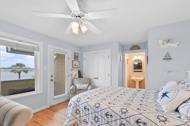 bedroom with light wood-style floors, ensuite bath, a ceiling fan, and baseboards