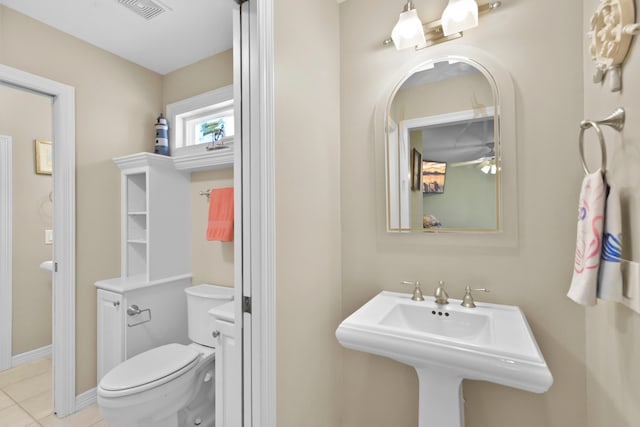 bathroom with tile patterned flooring, visible vents, toilet, and a sink