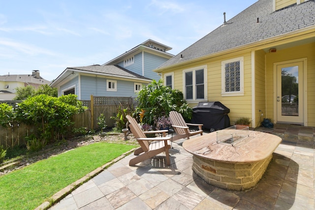 view of patio / terrace with fence, a fire pit, and area for grilling