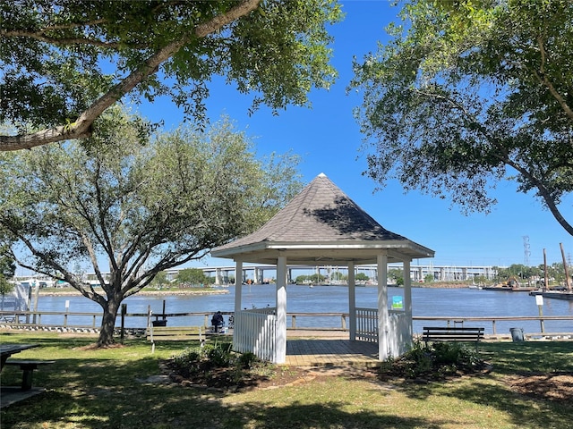 dock area with a gazebo, a lawn, and a water view