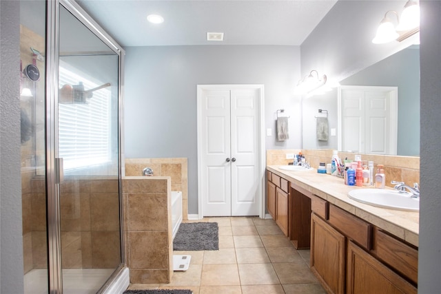 bathroom featuring a shower stall, a garden tub, tile patterned flooring, and a sink