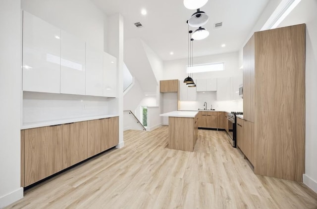 kitchen featuring modern cabinets, gas range, a sink, and a kitchen island