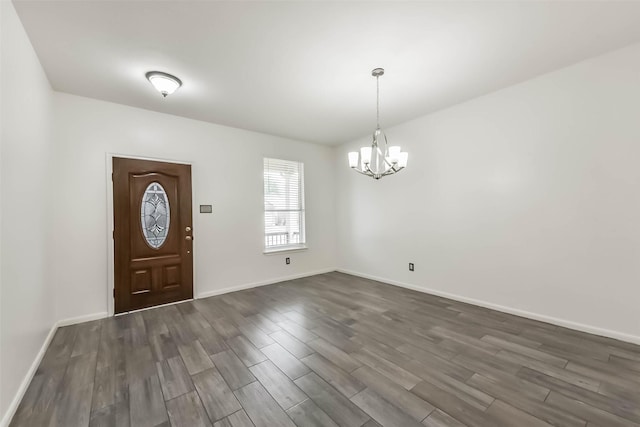 entrance foyer featuring a chandelier, baseboards, and dark wood-style flooring