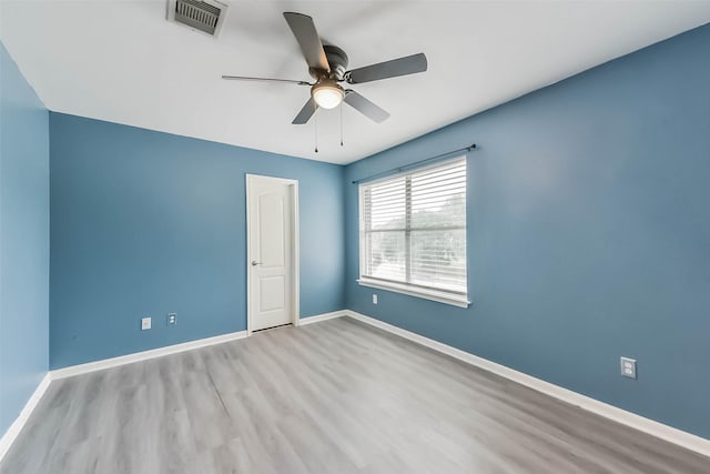 unfurnished room featuring ceiling fan, baseboards, wood finished floors, and visible vents