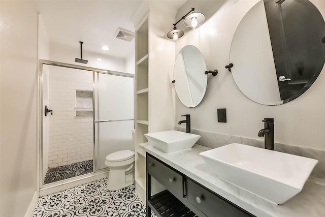 full bath with toilet, a sink, double vanity, and a stall shower