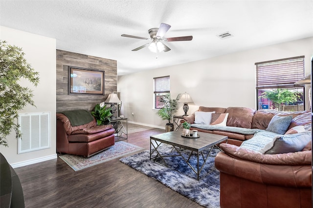living room with baseboards, wood finished floors, visible vents, and a ceiling fan