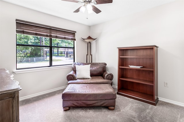sitting room with baseboards, a ceiling fan, and carpet flooring