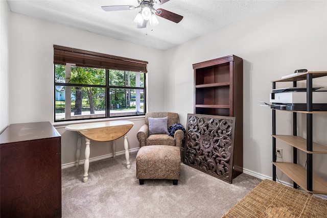 living area with ceiling fan, baseboards, and carpet flooring