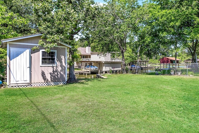 view of yard featuring an outdoor structure, fence, and a shed