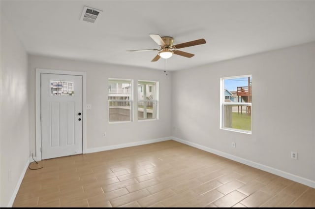 foyer entrance featuring ceiling fan, baseboards, and light wood-style flooring