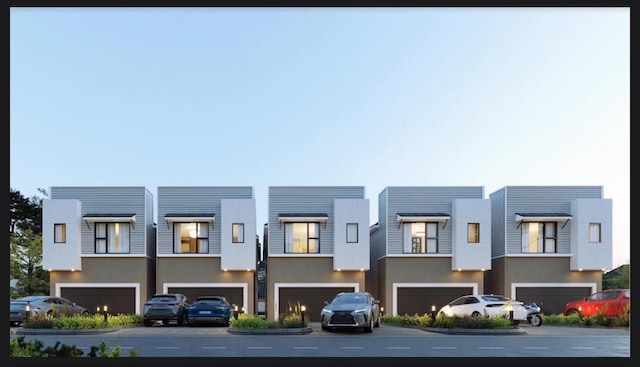 multi unit property with an attached garage and stucco siding